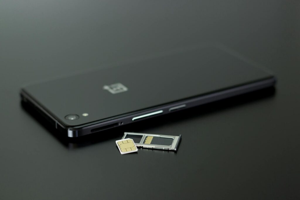 hand holding smartphone with sim card tray open